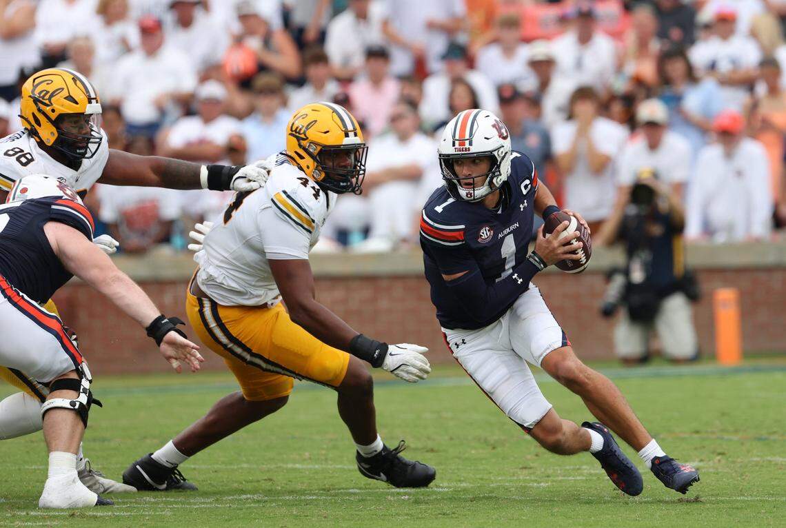 Sep 7, 2024; Auburn, Alabama, USA;  Auburn Tigers quarterback Payton Thorne (1) scrambles from California Golden Bears defenders during the third quarter at Jordan-Hare Stadium. Mandatory Credit: John Reed-Imagn Images