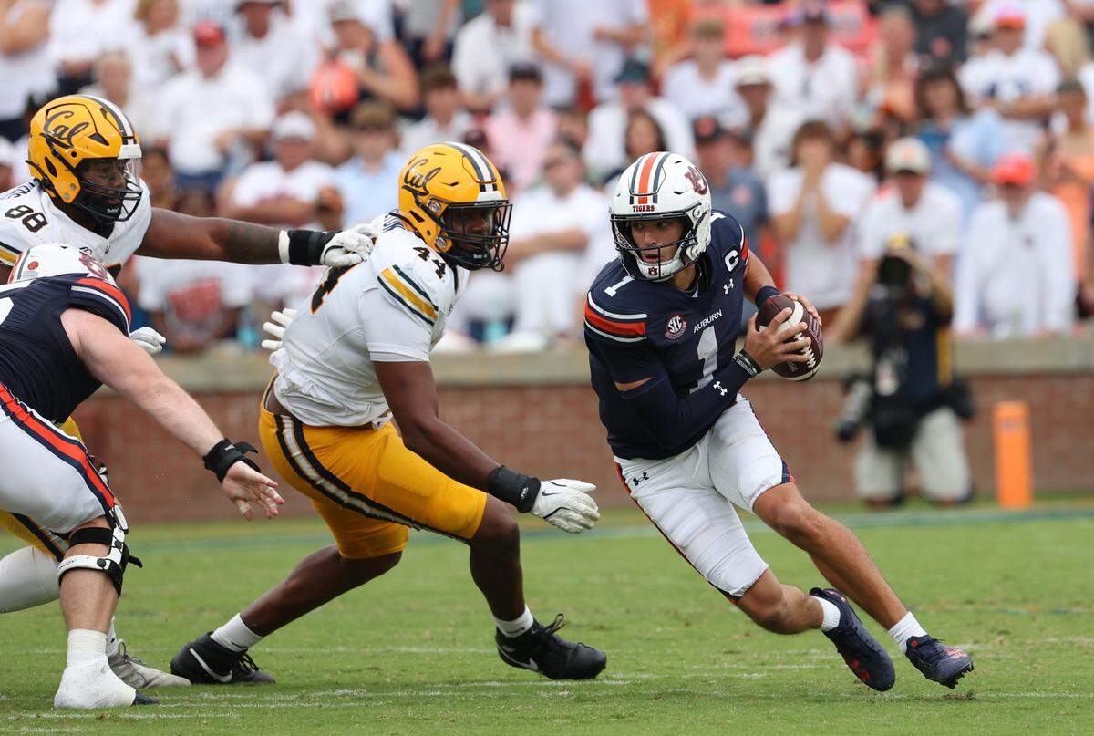 Sep 7, 2024; Auburn, Alabama, USA;  Auburn Tigers quarterback Payton Thorne (1) scrambles from California Golden Bears defenders during the third quarter at Jordan-Hare Stadium. Mandatory Credit: John Reed-Imagn Images