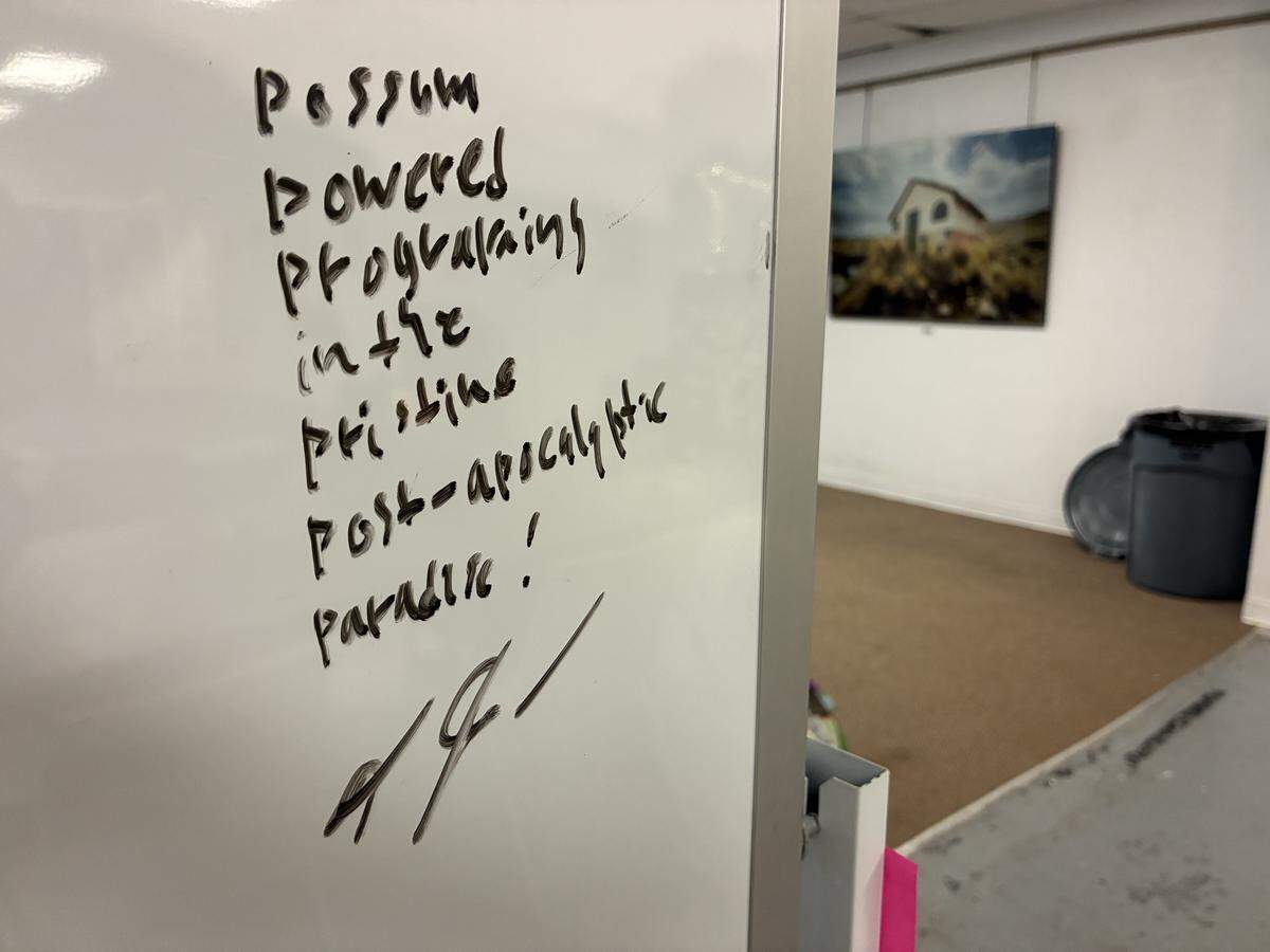 A whiteboard inside WMMT 88.7 FM’s studio on Nov. 14, 2025, in downtown Whitesburg, Ky, reads: “Possum-powered programming in the pristine post-apocalyptic paradise.”