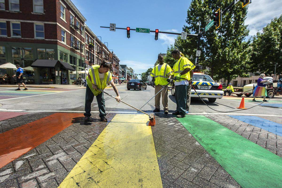 Jacob Troxell, from left, Jameel Cox and Andre Kenerly, members of the Lexington Streets and Roads community service crew, clean the rainbow-painted crosswalk at the intersection of Short Street and North Limestone Friday, June 28, 2019.
