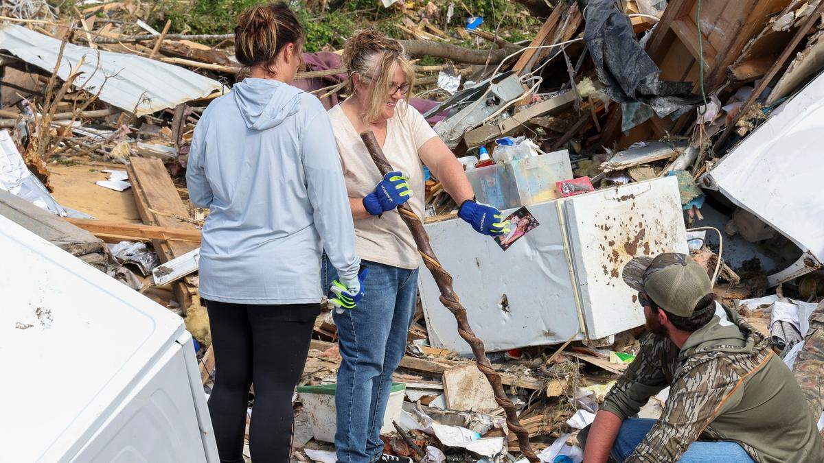 Edwina Wilson shows friends and family members photos as they clean up and take items to be saved from their Sunshine Hills home, Sunday, May 18, 2025 in London, Ky. Wilson’s home was destroyed when a deadly tornado ripped through the neighborhood two days earlier. Her and her husband, David, stayed in the home during the storm. “The walls just fell down around them,” Joe Wilson, their son said.