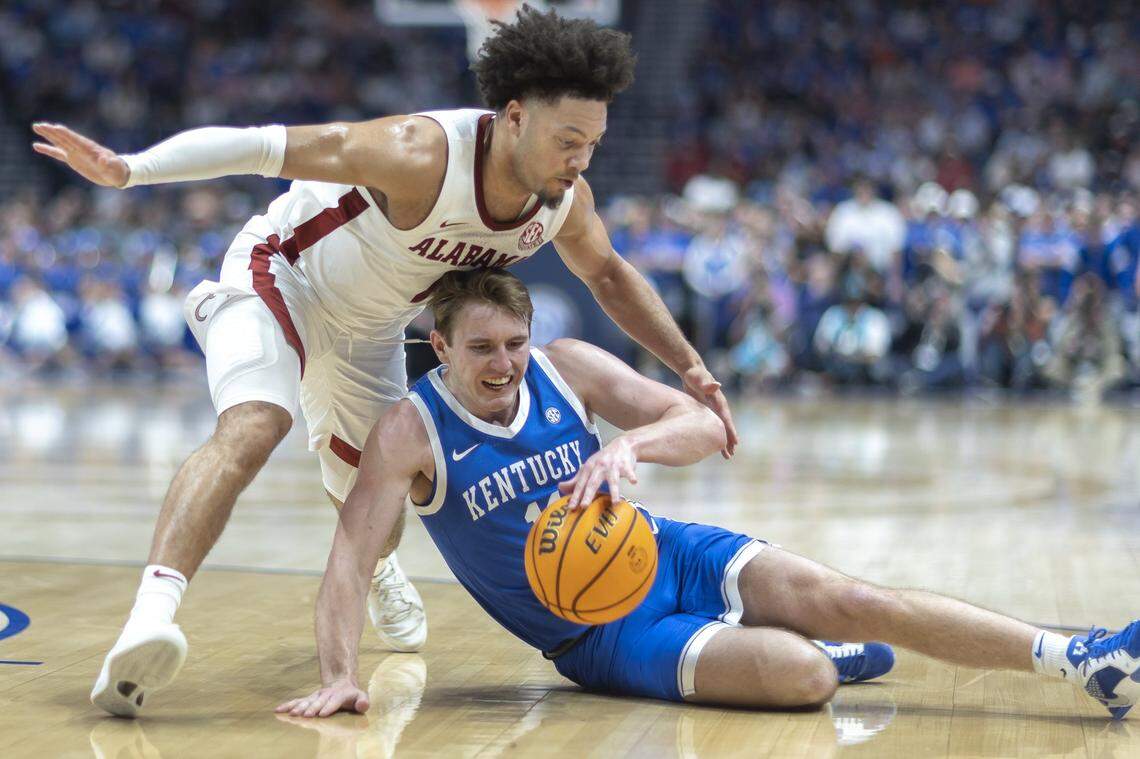 Kentucky guard Travis Perry (11) battles for the ball with Alabama guard Mark Sears (1) during Friday’s game at Bridgestone Arena in Nashville, Tennessee.