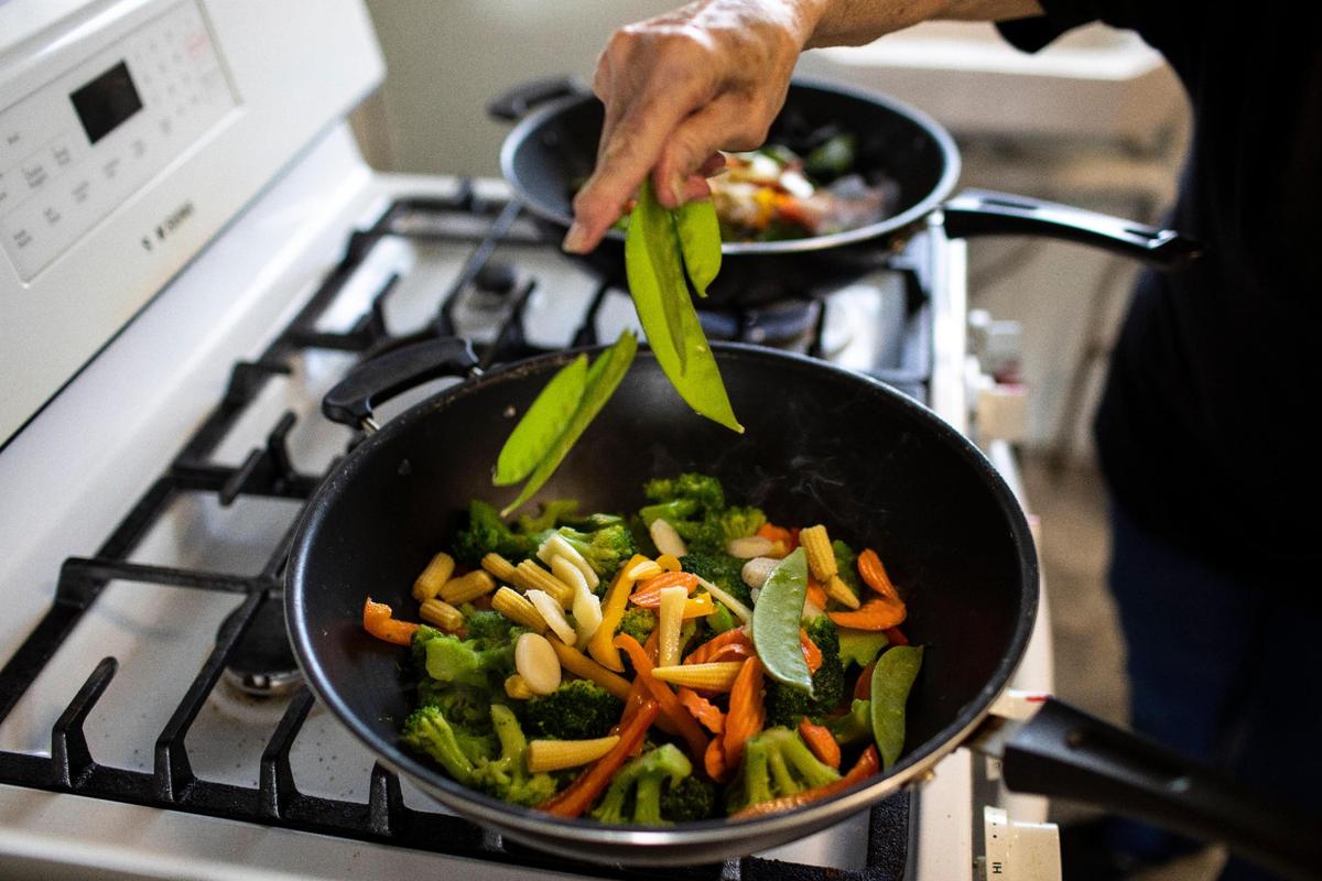 Bonnie Winfrey prepares one of her most popular dishes, stir-fry, at BebeÕs Kitchen in Jeffersonville, Ky., Tuesday, March 16, 2021.