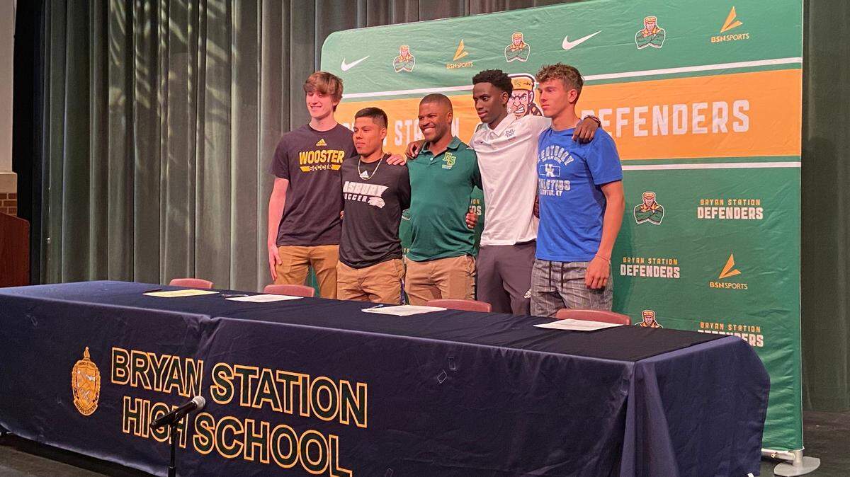 From left to right, Evan Amend, Mario Fuentes, boys’ soccer head coach Manes Preptit, Steven Mahirwe and Max Miller pose for a photo inside the Bryan Station High School auditorium on Monday night after a college signing ceremony. All four players will play in college, headlined by Miller joining Kentucky.