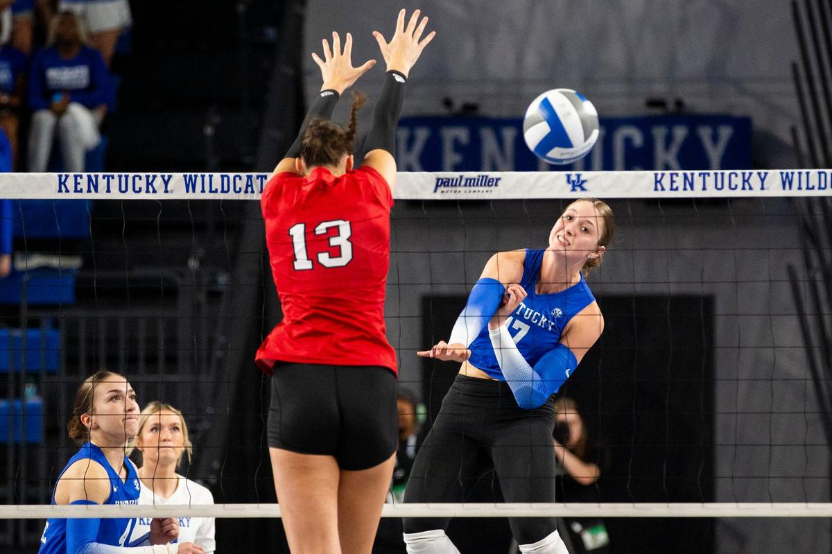 Kentucky’s Brooklyn DeLeye spikes a ball in front of Louisville’s Cara Cresse during Wednesday night’s match in Memorial Coliseum. The Cardinals beat the Wildcats for the fourth consecutive time.