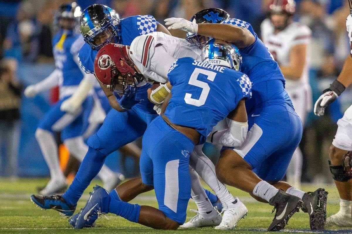 Kentucky Wildcats linebacker DeAndre Square (5), Kentucky Wildcats defensive lineman Justin Rogers (52) and Kentucky Wildcats linebacker D’Eryk Jackson (54) tackle South Carolina Gamecocks quarterback Spencer Rattler (7) during a game at Kroger Field in Lexington, Ky., on Saturday, Oct. 8, 2022.