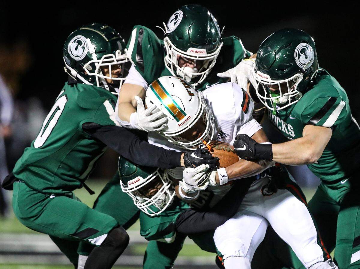 The Trinity defense stops Pharo Watts of Frederick Douglass during the fourth quarter. Watts carried 24 times for 117 yards on Friday night but the Broncos managed only seven points against the Shamrocks.