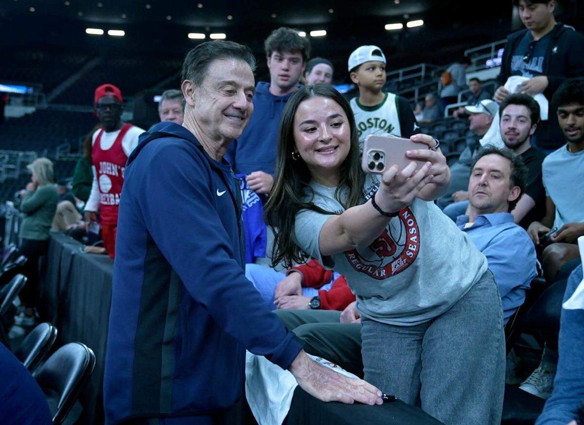 Marisa Mazzuca of New Jersey, who’s dad went to St. John’s, takes a photo with Red Storm head coach Rick Pitino, whose team is the No. 2 seed in the NCAA West Regional.