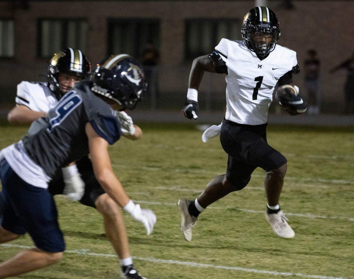 Milton's  Raymond Cottrell (No. 1) looks for room to run as the Gulf Breeze defense closes in during Friday night's gridiron action.Milton Vs Gulf Breeze Football