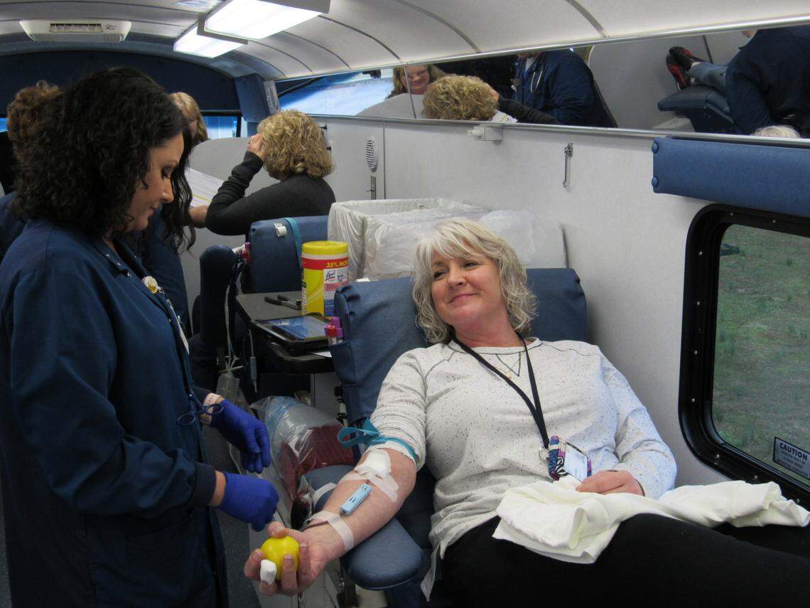Melissa Cowan, left, drew blood from Trese Frowein on March 16, 2020 at a mobile drive at Senture, a call center in Wayne County where Frowein works.