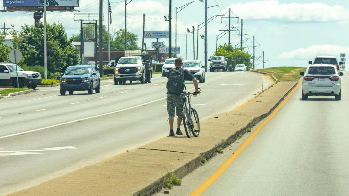 A person attempts to cross New Circle Road in Lexington, Ky., on Monday, Aug. 12, 2024.