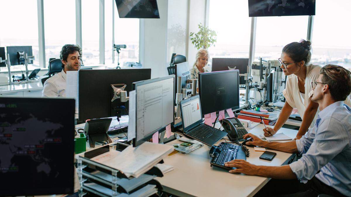 Business people working in modern office. Team working at desks in busy office.