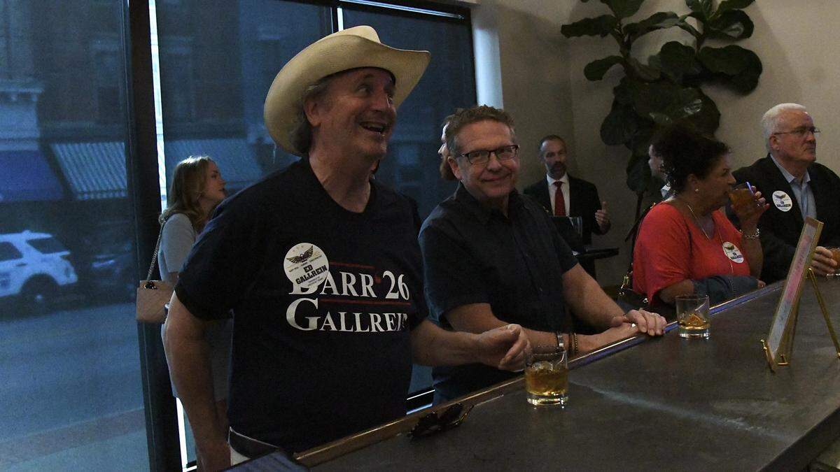 Steve Frank, former vice mayor of Covington, Ky. (left), and Tony Milburn, the owner of Wenzel Distillery, order drinks at the bar during the primary election watch party for Ed Gallrein, who won the Republican nomination for Kentucky’s 4th Congressional District on May 19, 2026.
