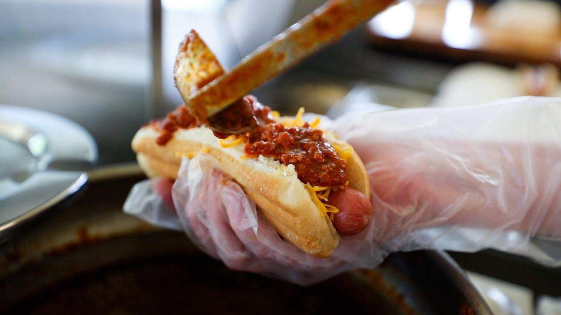 Chili is poured on top of a hot dog on Thursday, July 21, 2022, at Sam’s Hot Dog Stand in Lexington, Kentucky. The Lexington Green Circle location has closed after almost four years.