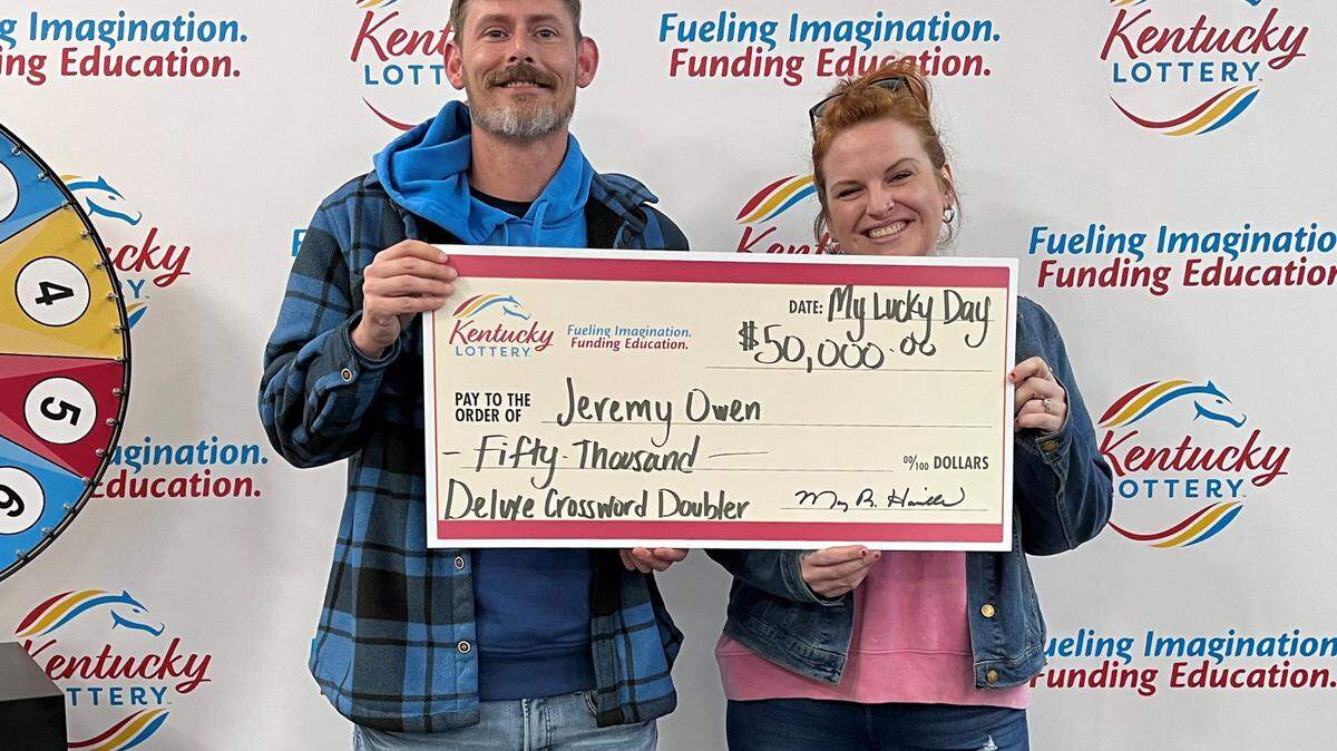 Jeremy Owen and wife Chelsea Hanson pose with their Kentucky Lottery winnings.