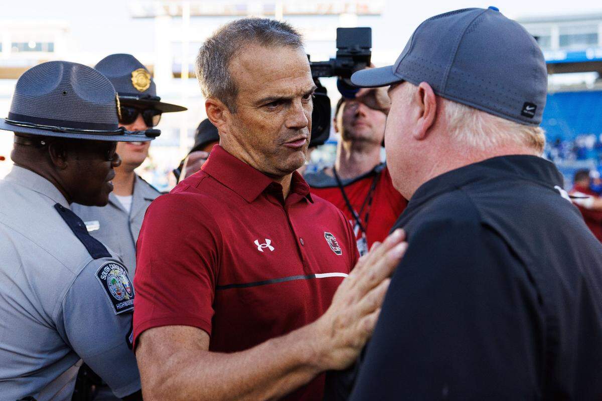 Sep 7, 2024; Lexington, Kentucky, USA; South Carolina Gamecocks head coach Shane Beamer talks with Kentucky Wildcats head coach Mark Stoops after the game at Kroger Field. Mandatory Credit: Jordan Prather-Imagn Images