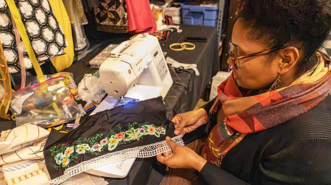 Local artist and activist fashion designer, Soreyda Benedit Begley positions fabric with stick pens for a perfectly stiched boarder in her small home studio on Jan. 21, 2026, in Lexington, Ky.