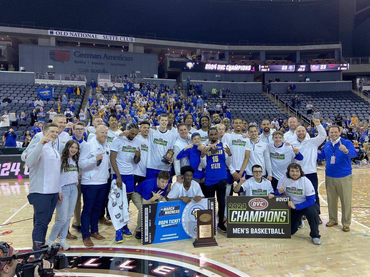 The Morehead State men’s basketball team poses with the Ohio Valley Conference Tournament trophy on the court at the Ford Center in Evansville, Indiana. The Eagles defeated Little Rock in finals to secure a spot in the NCAA Tournament.