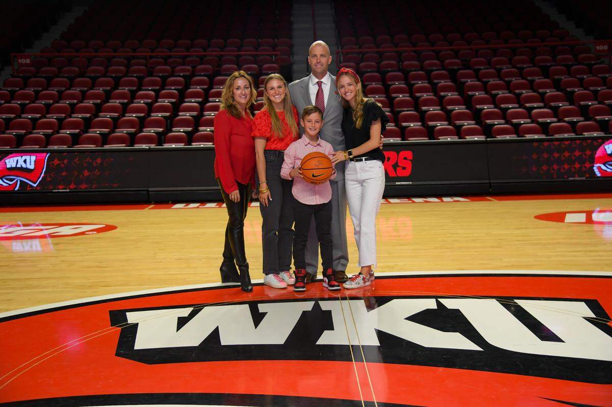 New WKU men’s basketball coach Steve Lutz (in necktie) posed with his family inside Diddle Arena. From left: Lutz’s wife, Shannon; daughter, Caroline; son, Jackson; and daughter, McKenna.