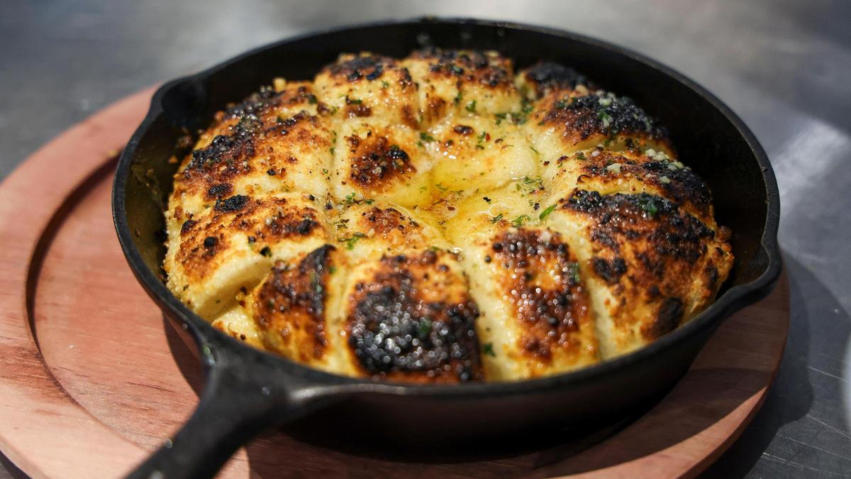 The Garlic Knots appetizer ($12) from Crust is baked in the Italian stone oven. The pull-apart bread is served with Parmesan and garlic sauce.