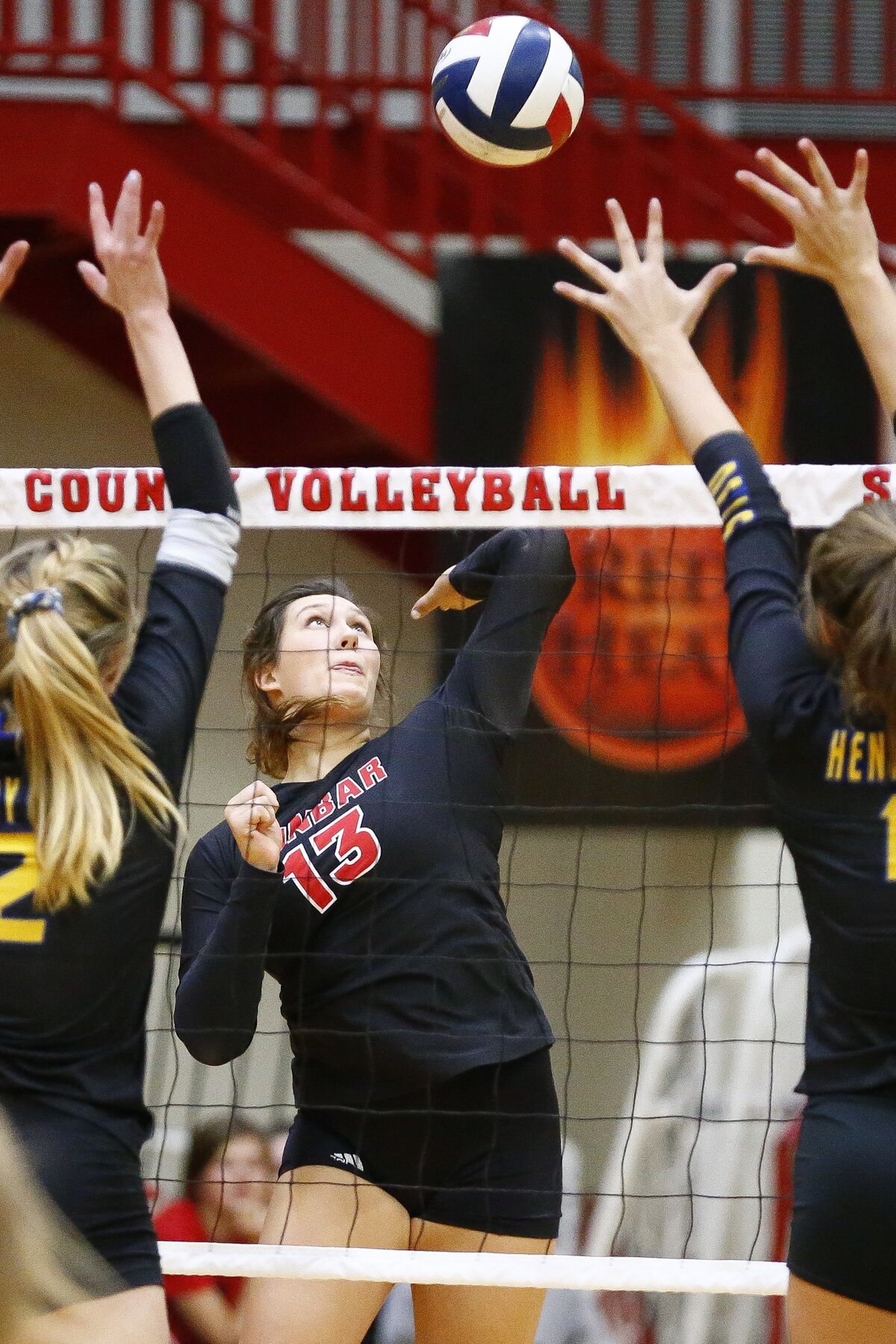 Paul Laurence Dunbar’s Peyton Gash (13) hits the ball past Henry Clay’s Emma Shadwick (2)  and Henry Clay’s Sydney Baker (11) during the 11th Region volleyball tournament semifinals Wednesday at Scott County High School in Georgetown. Paul Laurence Dunbar beat Henry Clay 3-0.