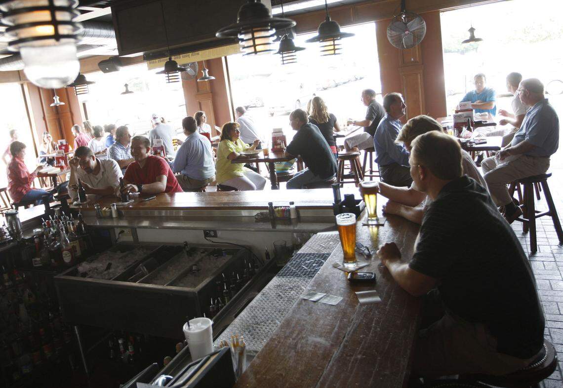 People sat at the bar at the Drake’s in Lansdowne, which has wide openings to the outside. BHG is building a third Lexington Drake’s off Leestown Road in Townley Center.