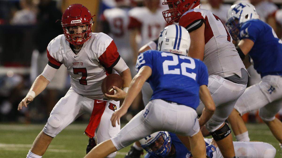 Scott County quarterback Cade McKee, 7, scrambles with the football against Highlands’ Shabaz Butt, 22, during the second quarter of a football game held at Highlands High School in Fort Thomas, Kentucky Friday, Aug. 31, 2018.
