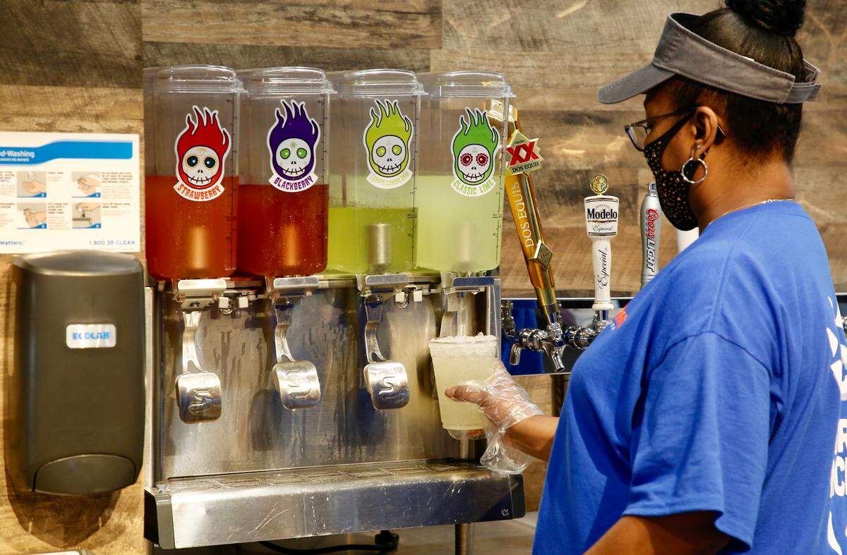 Tonya Cunningham prepares a to-go margarita May 9 at Hot Head Burritos. Four margarita flavors are offered: regular, strawberry, blackberry and Leroy’s Loaded Dew. They are also available through the drive-thru.