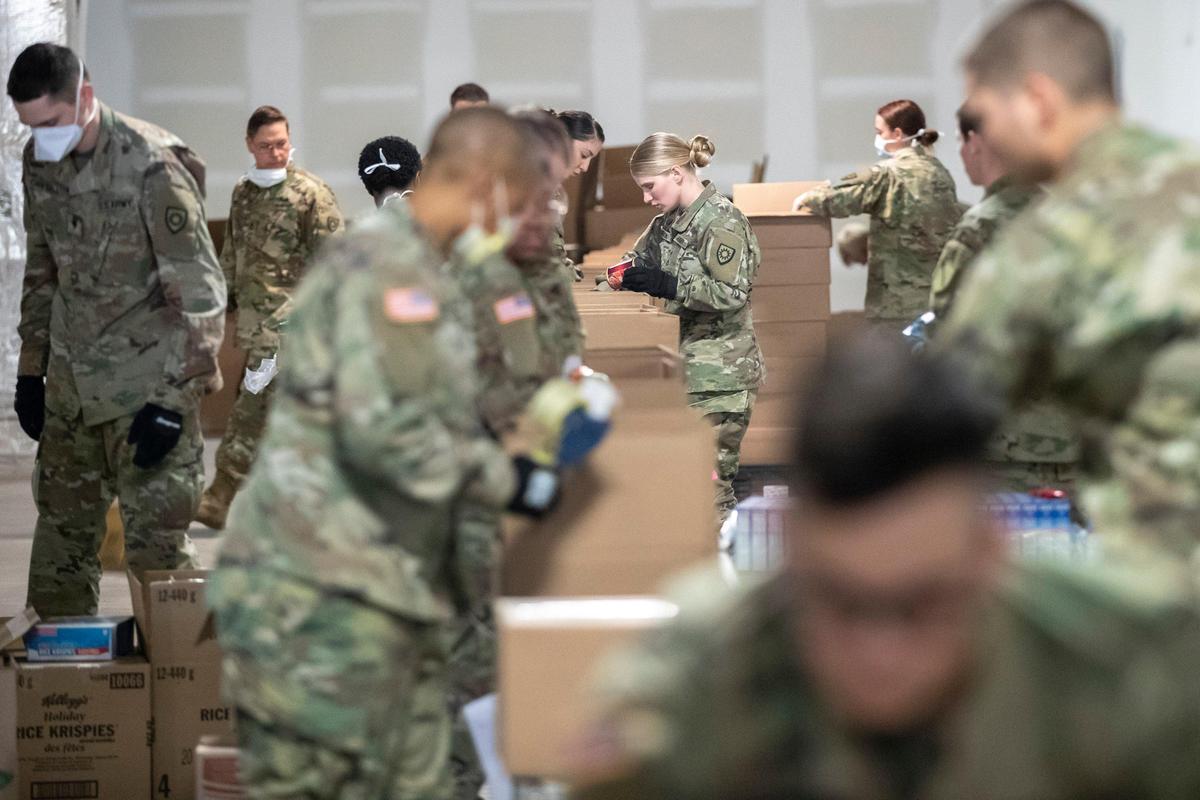 Members of the Kentucky National Guard help prepare boxes of food for God’s Pantry Food Bank in Lexington, Ky., Tuesday, April 7, 2020.