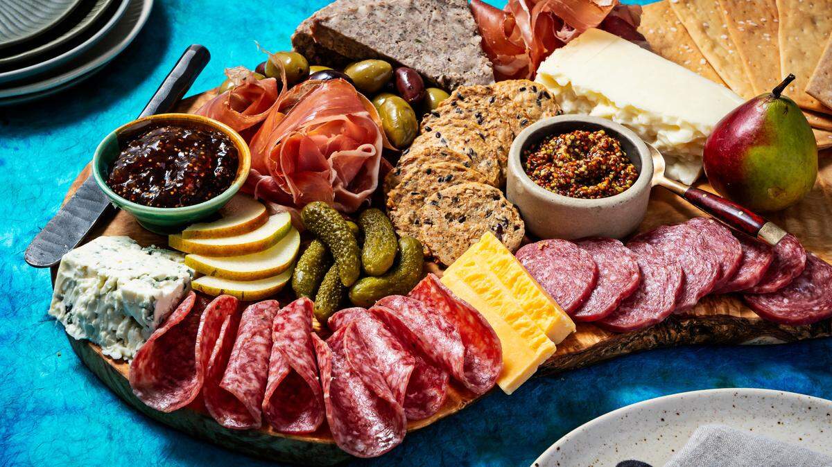 A true charcuterie board — finger foods arranged on a surface such as smoked and cured sliced meats, sausages, bread and wedges of cheese — are great for entertaining.