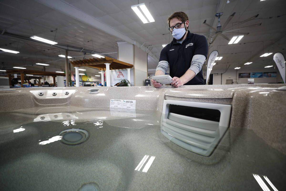 Salesman Justin Foster works to reset a hot tub remote Wednesday at Aurora Pools & Spas in Lexington. According to owner Scott Farmer, pools and spas are currently in high demand as people are staying home and working on their yards.
