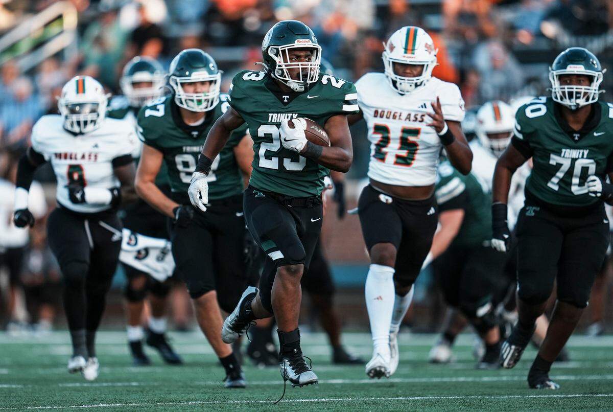 Trinity's Jamaurion Berry runs for a gain even with shoestrings flapping while the Rocks play against Frederick Douglass High School during KHSAA Class 6A football Friday, August 29, 2025 at R.W. Marshall Stadium in Louisville, Kentucky.
