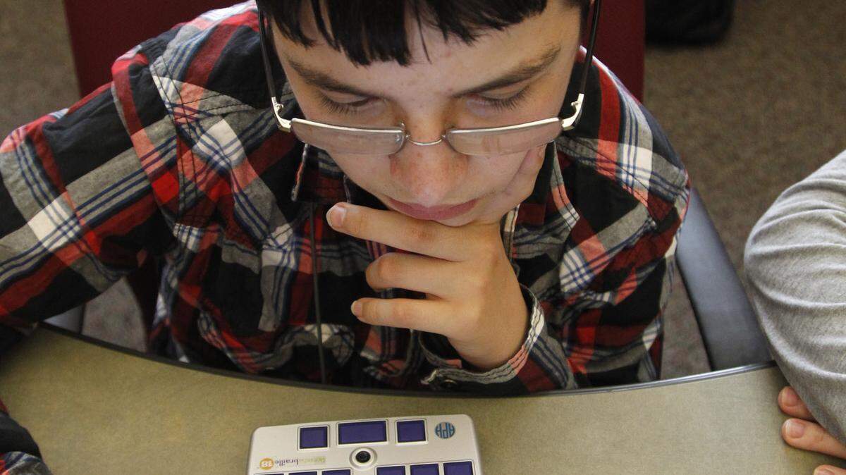 Joseph Boggs, who has hearing and vision problems, used a Braille display device connected to his iPad. Joseph, 13, has grown confident with technology thanks to training by the Kentucky Deaf-Blind Project.
