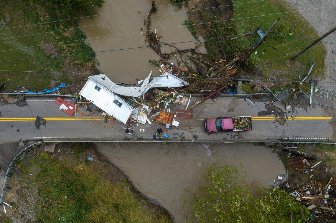 People work to clear a house from a bridge on KY-931 near the Whitesburg Recycling Center in Letcher County, Ky., on Friday, July 29, 2022.  