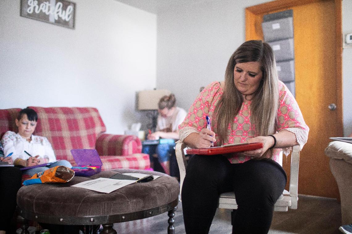 Megan Simpson works on a financial planning worksheet in a group workshop focused on finances at Living Clean transitional housing in Manchester, Ky., Wednesday, March 2, 2022.