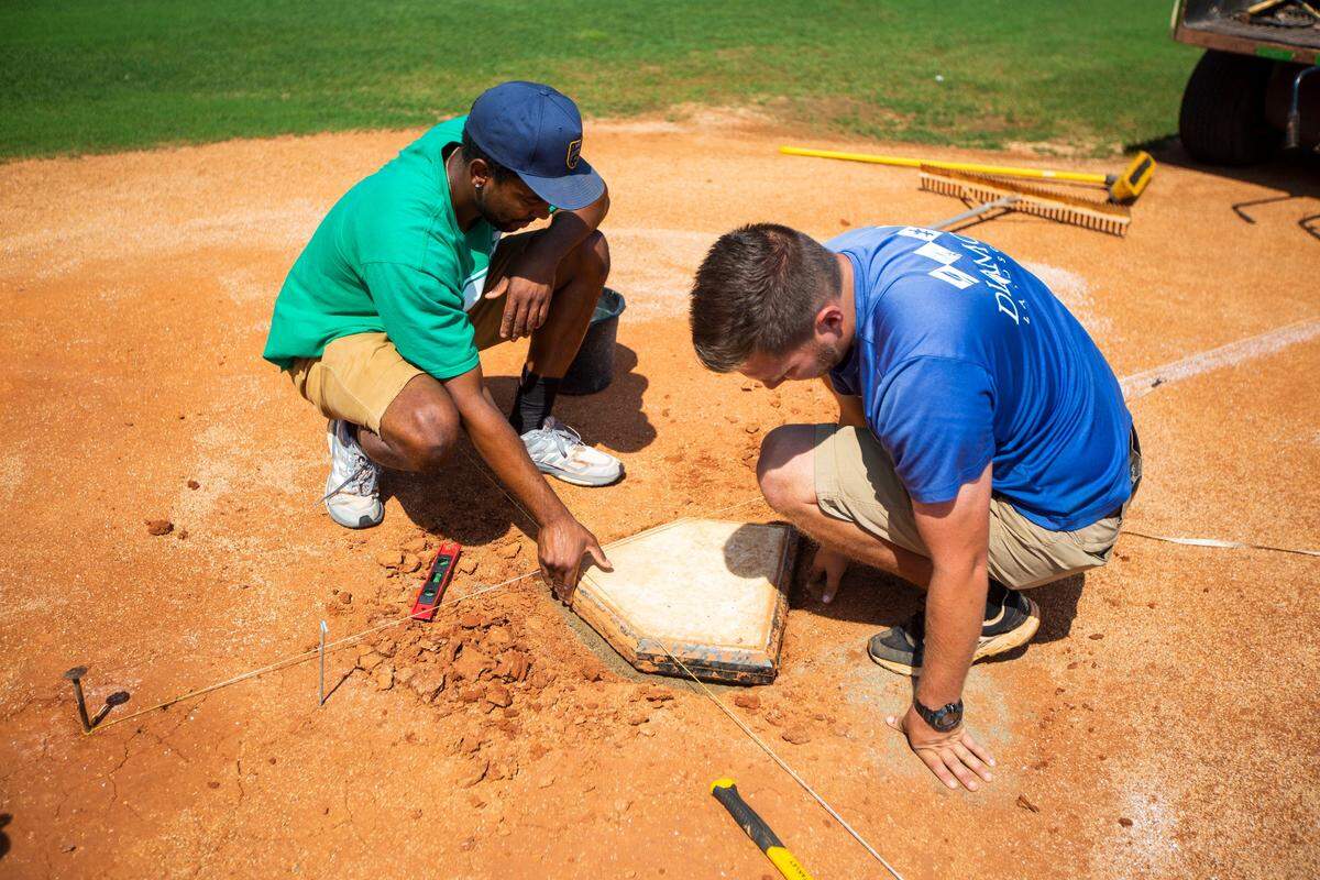 Lexington Legends head groundskeeper Jonathan Youngblood, left, and his assistant Dustin Spiegel worked on leveling home plate before a game at Whitaker Bank Ballpark.