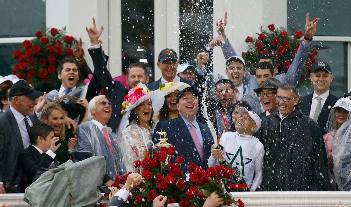 Winning jockey Mike Smith sprayed champagne after riding Justify to victory in the 144th running of the Kentucky Derby at Churchill Downs in Louisville, Kentucky. To the far left are Starlight Racing’s Jack and Laurie Wolf, to the right of Smith is Winstar Farm owner Kenny Trout, and just behind them is China Horse Club’s Teo Ah Khing, all of them part of Justify’s ownership group. 