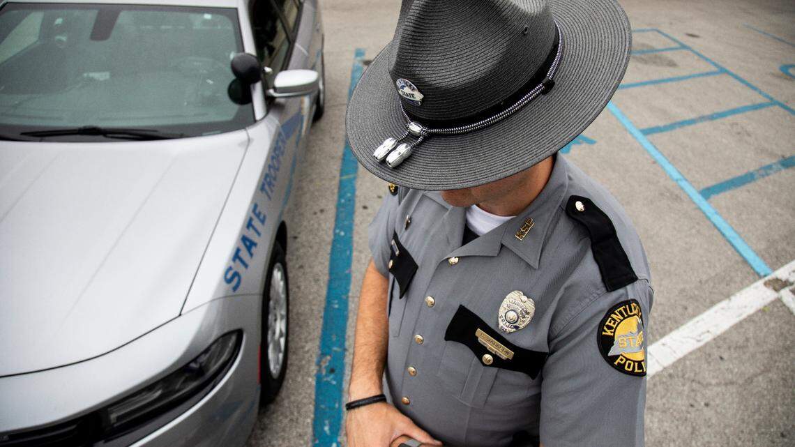 Kentucky State Police officer in hat by cruiser. 