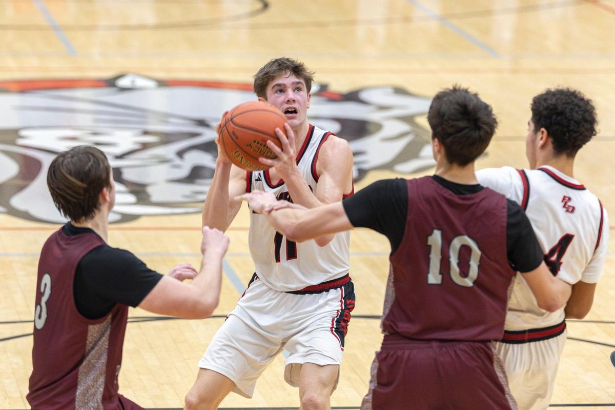 Paul Laurence Dunbar’s Asher Horn (11) looks to shoot in front of Tates Creek’s Brady Manning (3) and Tom Haubenreich (10) during their game at Paul Laurence Dunbar High School on Thursday.
