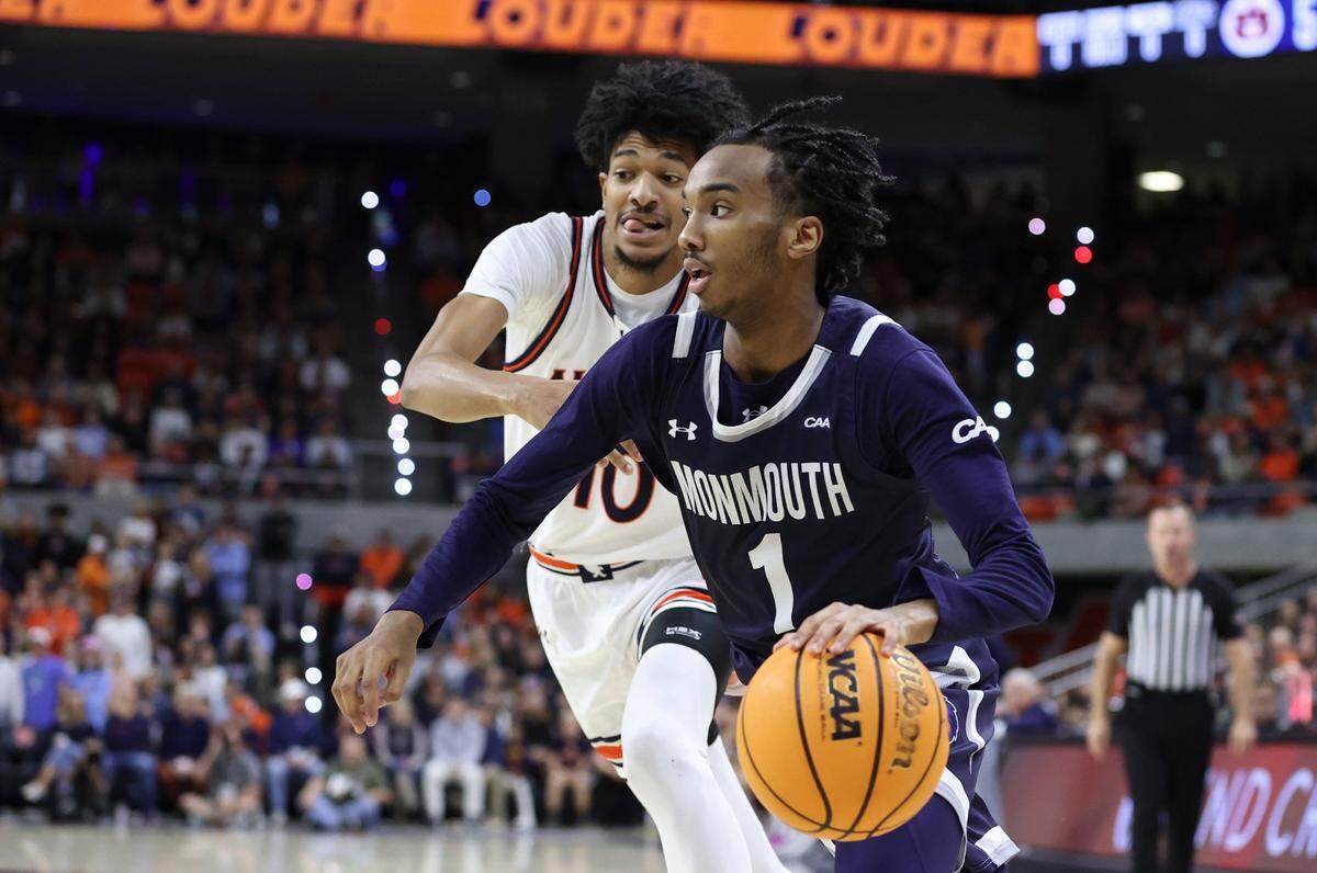 Dec 30, 2024; Auburn, Alabama, USA;  Monmouth Hawks guard Abdi Bashir Jr. (1) gets past Auburn Tigers guard Chad Baker-Mazara (10) during the first half at Neville Arena. Mandatory Credit: John Reed-Imagn Images
