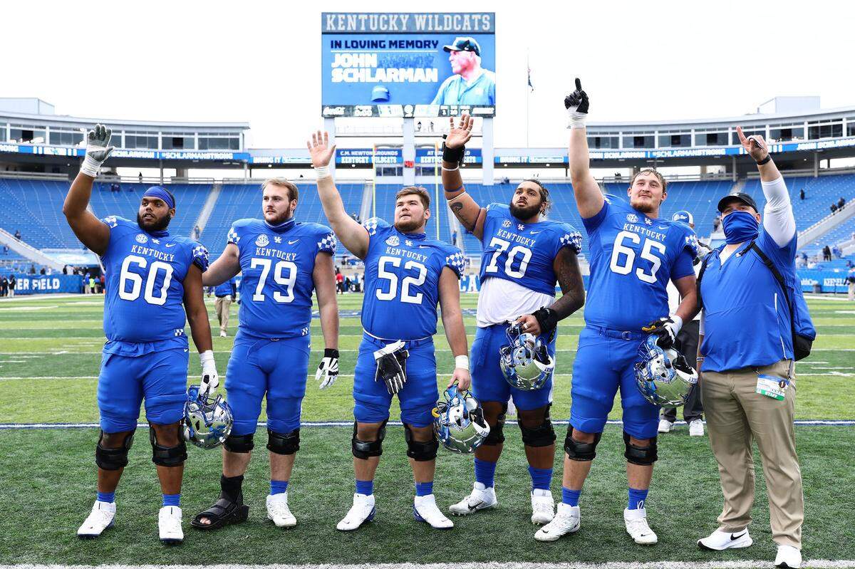 Some of Kentucky’s offensive linemen, including Quintin Wilson (60), Luke Fortner (79), Drake Jackson (52), Darian Kinnard (70) and Landon Young (wearing 65 in honor of the late John Schlarman), acknowledged Schlarman’s family in the stands following the team’s win over Vanderbilt in 2020.