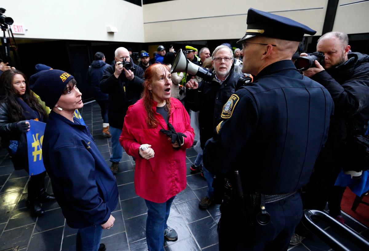 Reese Greer, middle, a Census Bureau employee, talked to a Lexington Police Sergeant after he asked them to leave the property as a gathering of federal employees and supporters held a rally Wednesday outside U.S. Senator Mitch McConnell’s Lexington office on Corporate Drive. They made speeches outside and then went inside the building to his office where they unsuccessfully attempted to deliver letters to his office, which was locked. Lexington Police officers soon arrived and had them leave the private property.