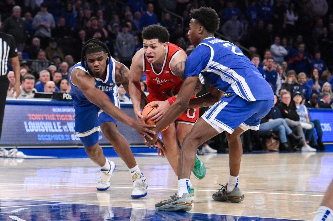 Dec 21, 2024; New York, New York, USA; Ohio State Buckeyes guard John Mobley Jr. (0) drives to the basket while being defended by Kentucky Wildcats guard Otega Oweh (00) and Kentucky Wildcats guard Jaxson Robinson (2) during the second half at Madison Square Garden. Mandatory Credit: John Jones-Imagn Images