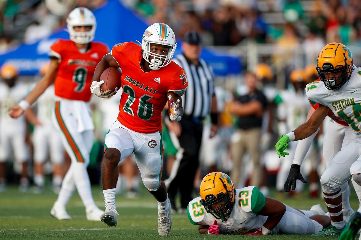 Frederick Douglass running back Davaun Hart (26) avoided a Bryan Station tackle during their game at Frederick Douglass High School last Friday.