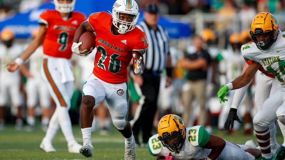 Frederick Douglass running back Davaun Hart (26) avoided a Bryan Station tackle during their game at Frederick Douglass High School on Aug. 19, 2022.