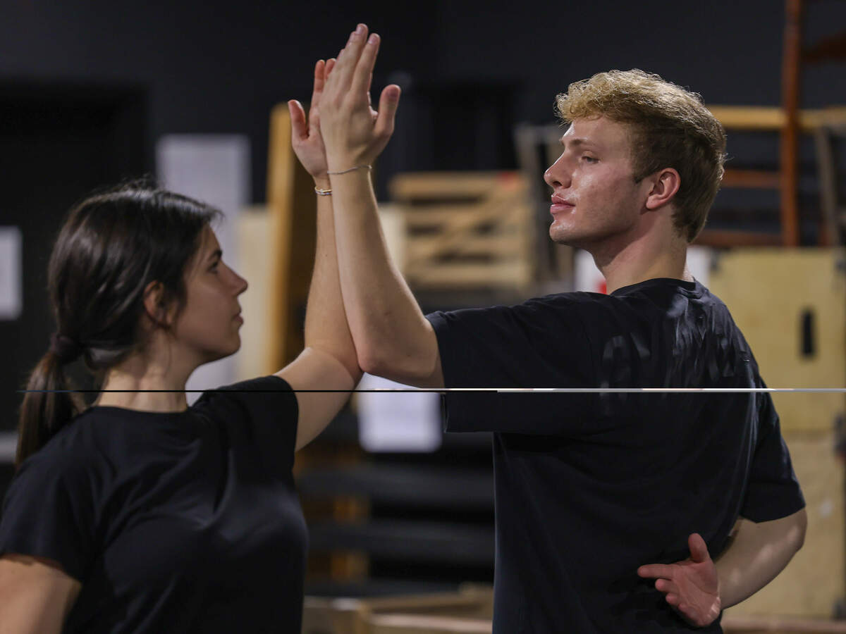 Haley O’Donnell and Caleb Sporrer practice the steps of a partner dance during rehearsal.