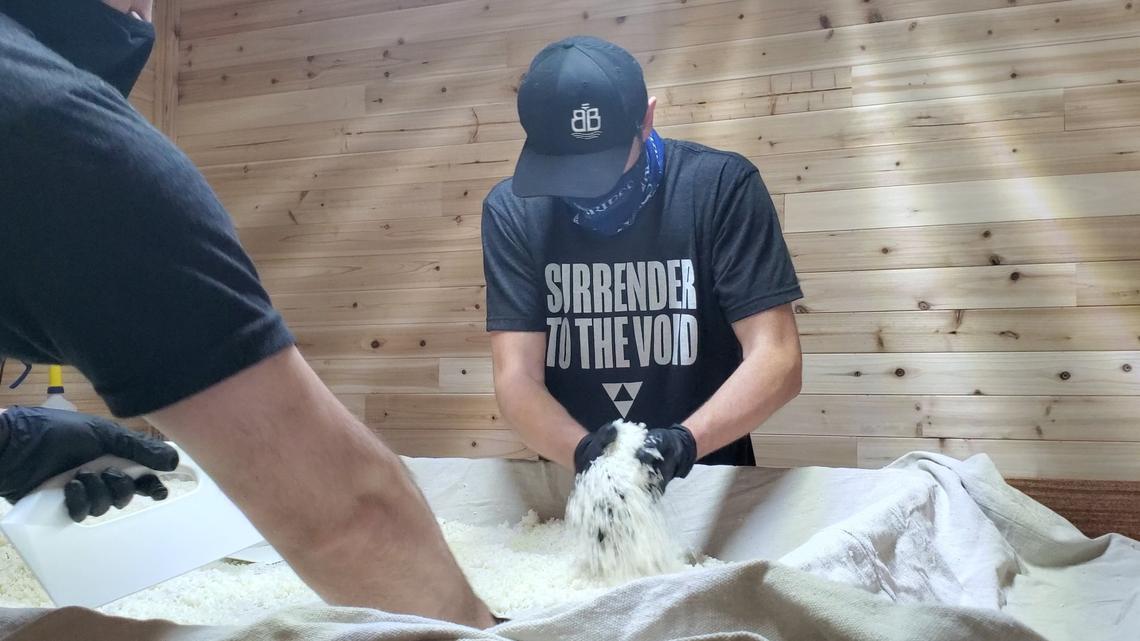 The Void Sake head brewer Justin LeVaughn, right, helps separate rice used in the production of Sake. Jan. 28, 2021.