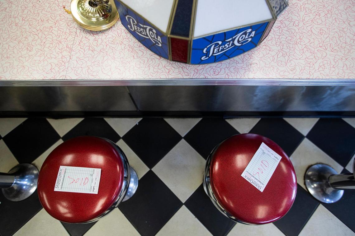 Patrons buy fixtures, menus and merchandise from Parkette Drive-In during a sale in Lexington, Ky., Saturday, July 23, 2022.