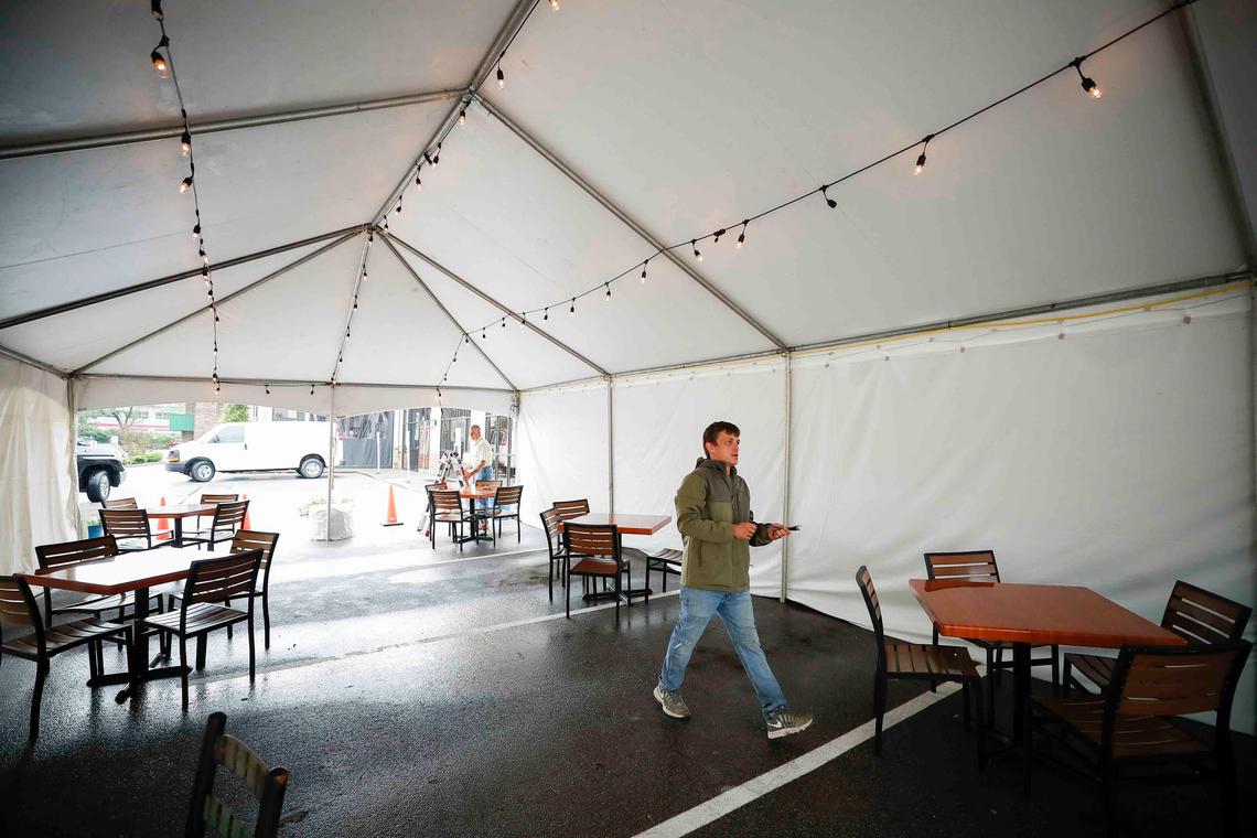Corey Sanders works in a 20x40 foot tent Tuesday in the parking lot Ramsey’s Diner on Zandale Drive. The tent will offer seating for at least 10 tables.