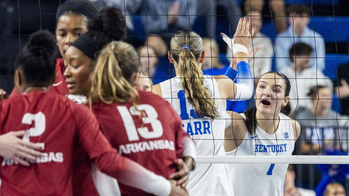 Kentucky outside hitter Eva Hudson, right, celebrates a point with middle blocker Lizzie Carr during UK’s 3-0 win against Arkansas on Nov. 16.